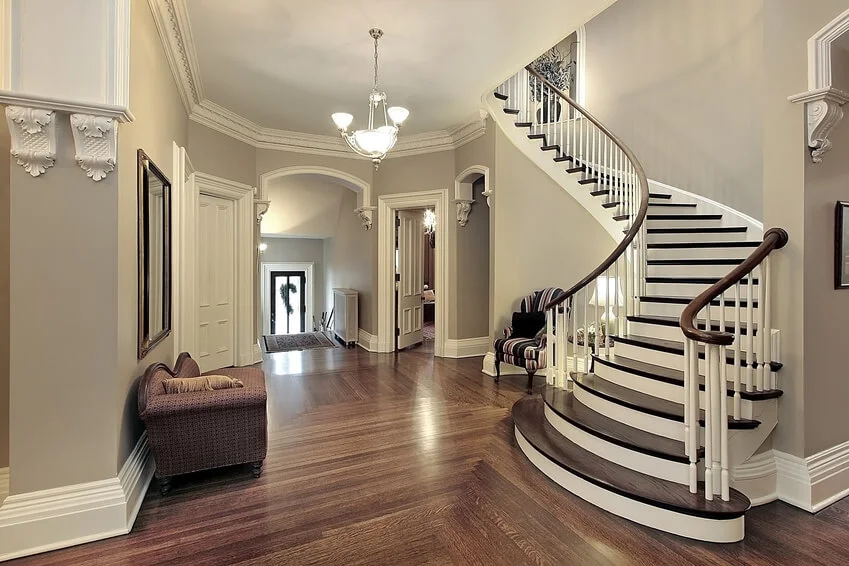 Elegant grand foyer and custom curved staircase renovation in a luxury home completed by JD Local Builders in San Antonio, TX.