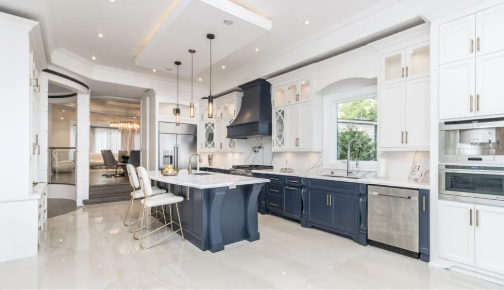 A high-end remodeled luxury kitchen in San Antonio, TX, featuring navy blue cabinets, white quartz countertops, a kitchen island, and modern pendant lighting, completed by JD Local Builders.
