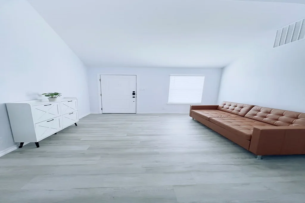 Modern living room interior after a complete home remodeling project by JD Local Builders in San Antonio, Texas, featuring light wood flooring and contemporary furniture.